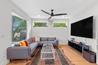 Living area featuring a ceiling fan, baseboards, 