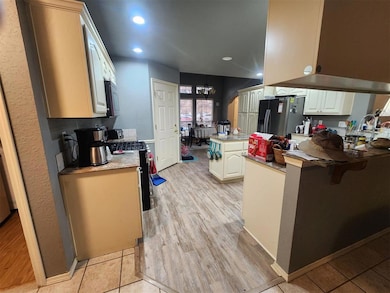 Kitchen featuring kitchen peninsula, white cabinetry, and stainless steel appliances