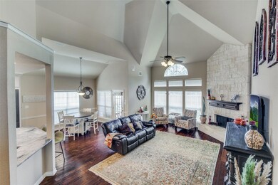 Living room with a stone fireplace, dark wood floo