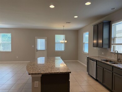 Kitchen featuring a sink, dishwasher, a chandelie