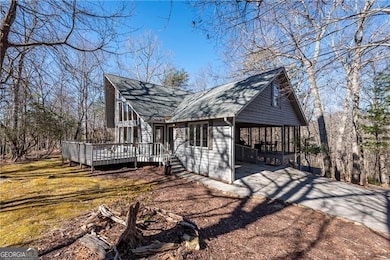 View of side of home featuring a deck, a shingled 