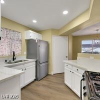 Kitchen featuring white cabinetry, light counterto