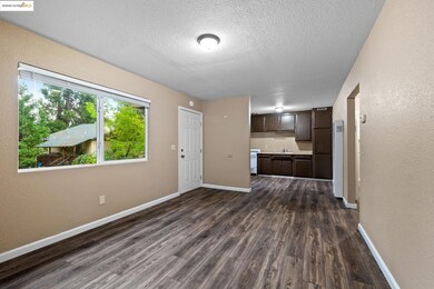Unfurnished living room featuring a textured wall, dark wood-style floors, a textured ceiling, and a heating unit