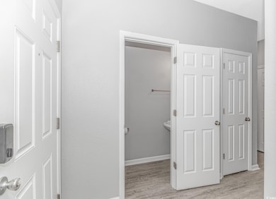 Hall with light wood-style flooring and baseboards