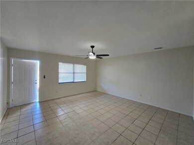 Empty room featuring light tile patterned floors and a ceiling fan