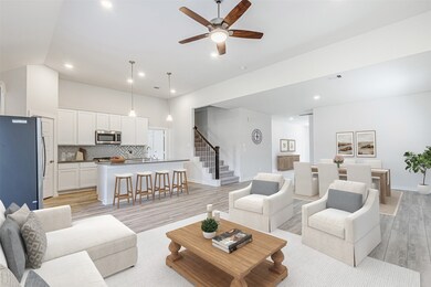 The main living area is open to the designer kitchen and features high ceilings, lots of natural light and high-end vinyl plank flooring. Virtually staged.