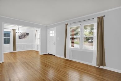 Entrance foyer featuring crown molding, light wood-type flooring, and a chandelier