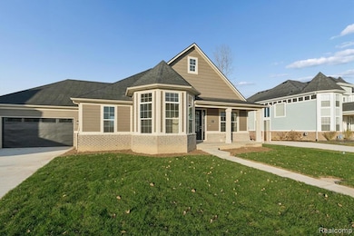 View of front of property with a porch, brick siding, a front yard, concrete driveway, and an attached garage
