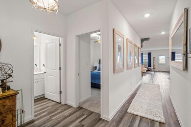 Corridor featuring dark wood finished floors, baseboards, and recessed lighting