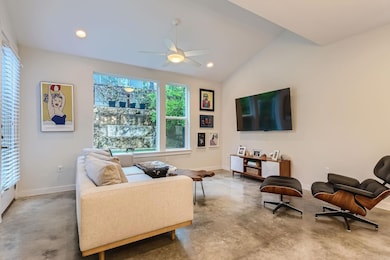 Living room with concrete floors, baseboards, cei