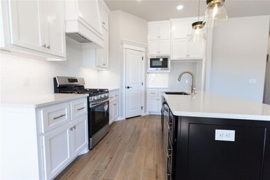 Kitchen featuring pendant lighting, white cabinets