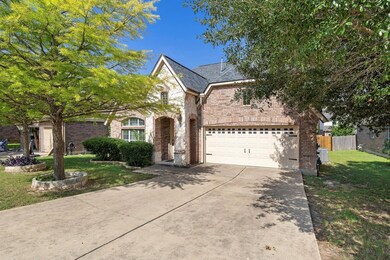 View of front facade with brick siding, driveway,