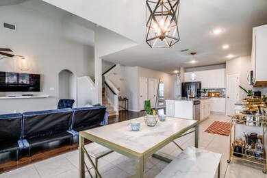Dining room with stairway, light tile patterned floors, a chandelier, recessed lighting, and arched walkways
