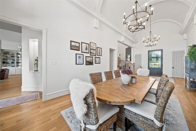 Dining space with light wood-type flooring, high v