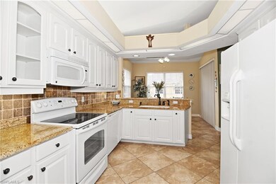 Kitchen with granite countertops and tile backspla
