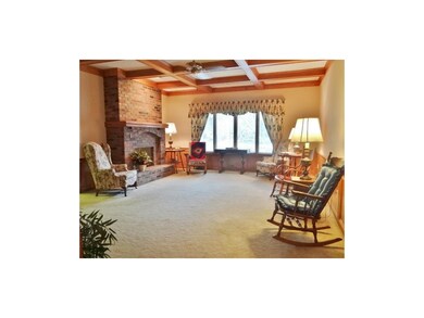 The great room offers fresh carpeting, a boxed ceiling, large window for plenty of natural lighting & a large see-thru brick fireplace.