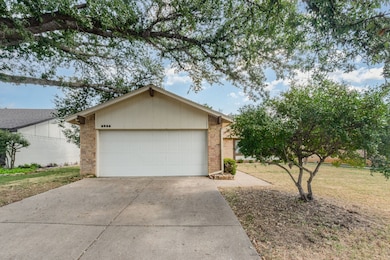 View of front of house featuring brick siding, driveway, an attached garage, and a front yard