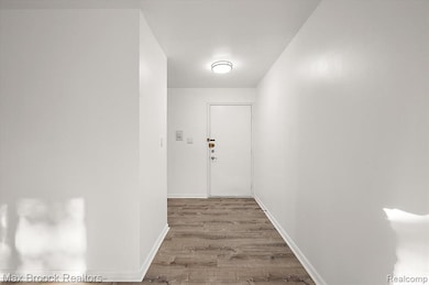 Corridor with baseboards and light wood-type flooring