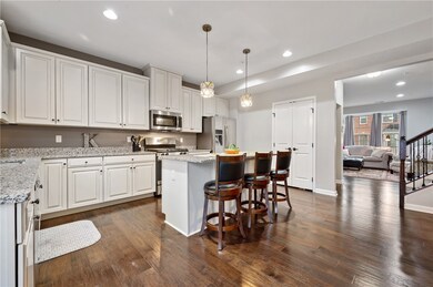 The exquisite eat-in kitchen boasts gleaming hardw