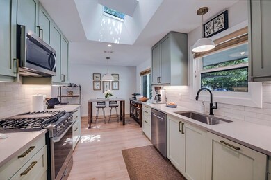 Kitchen with stainless steel appliances, a skylig
