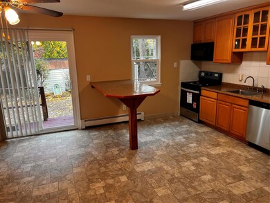 Kitchen with stove, stone finish flooring, dishwasher, tasteful backsplash, and glass insert cabinets