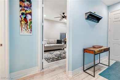 Hallway featuring baseboards, recessed lighting, and wood finished floors