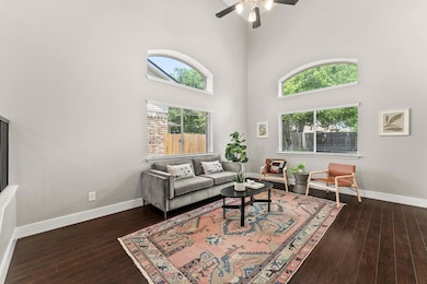 Living room with a towering ceiling, ceiling fan,