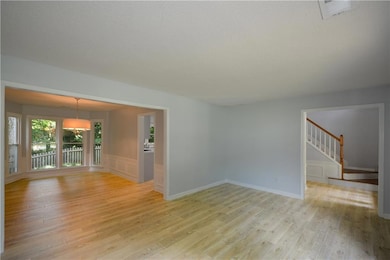 Unfurnished room featuring light wood-type flooring and stairs