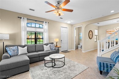 Living area with a ceiling fan, light tile floors.