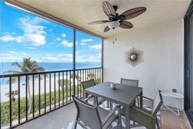 Sunroom / solarium with a beach view, ceiling fan, and a water view