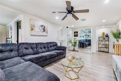 Living area featuring light wood-style floors, ceiling fan, and recessed lighting