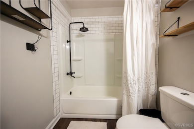 Bathroom with shower / tub combo, subway tile, toi