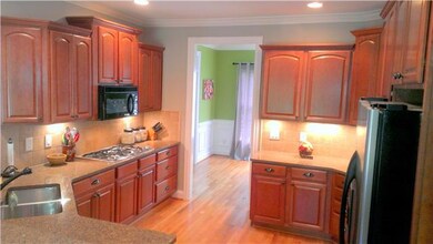 Handsome maple cabinets offer plenty of room to hold all the necessary kitchen sundries in this canteen kitchen. Beautiful granite counters & custom under-lighting creates a dramatic effect.. Warm hardwood floors continue to the dining room.
