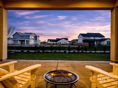 Patio terrace at dusk featuring a patio, a residential view, and a fire pit