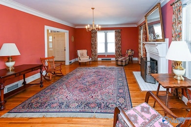 This room is spacious for all types of furnishings. Original Hard Woods, tall ceilings, and crown Molding.