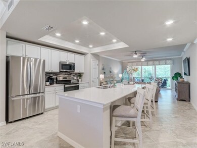 Kitchen featuring a center island with sink, white