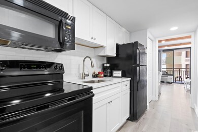 Kitchen featuring sink, white cabinets, backsplash