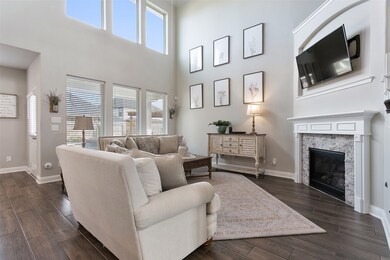 Spacious family room with great natural lighting from the wall of windows, stacked stone fireplace, high ceilings and fan.