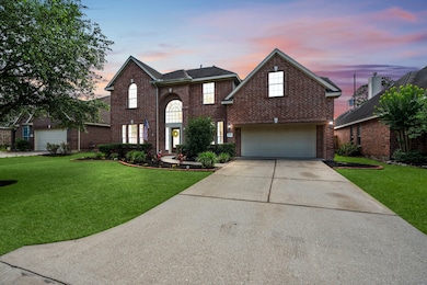 Elegant two-story brick home with arched entry, ta