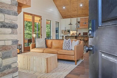 Living area featuring vaulted ceiling, dark wood finished floors, wooden ceiling, recessed lighting, and wooden walls
