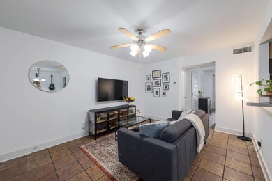 Living area with ceiling fan and baseboards