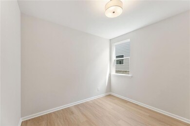 Unfurnished room featuring light wood finished floors and baseboards