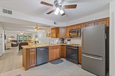 Kitchen with a sink, ceiling fan, stainless steel appliances, and visible vents