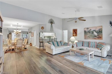 Living room with ceiling fan with notable chandeli