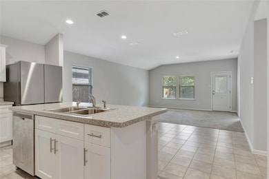 Kitchen with a kitchen island with sink, stainless