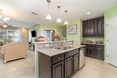 Kitchen featuring a sink, stainless steel dishwasher, light tile patterned flooring, and open floor plan