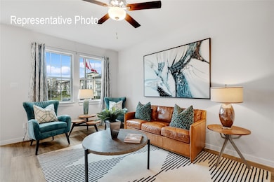 Living room with ceiling fan and light hardwood / wood-style flooring