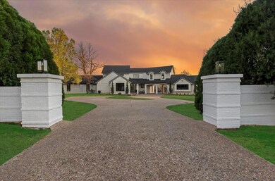 View of front facade with fence, curved driveway, 