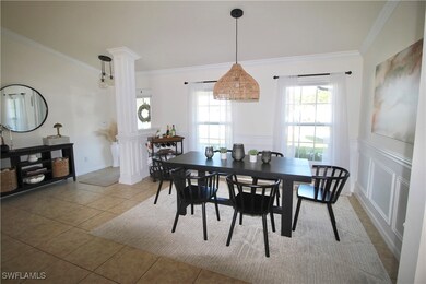 Tiled dining space featuring decorative columns, a