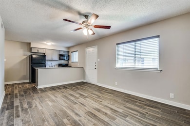 Kitchen featuring dark wood-style floors, a penins